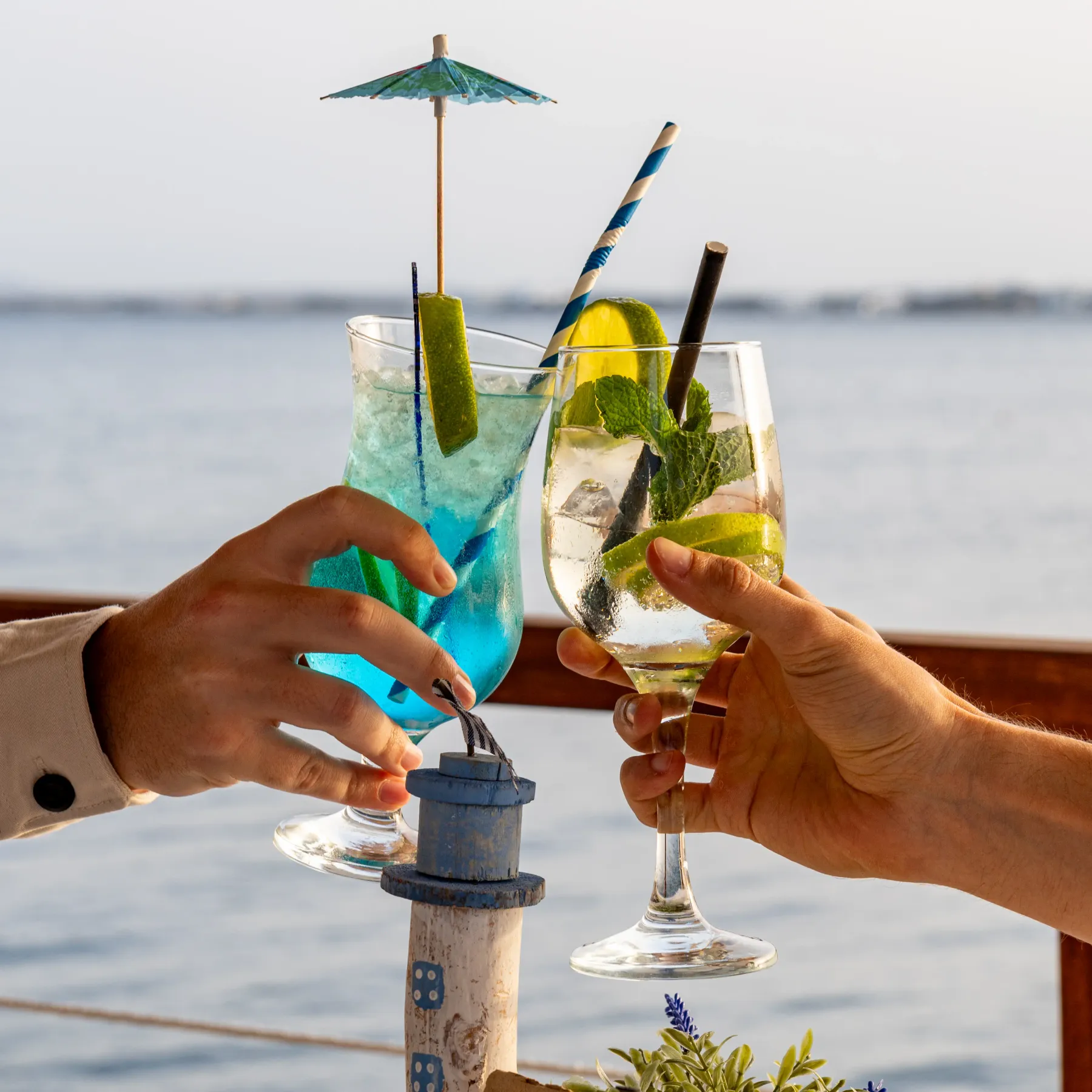 Brindis con cócteles de colores en la terraza de Aqua frente al mar
