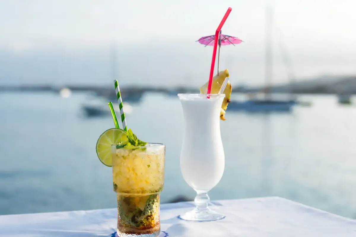 Piña colada y cóctel frente a los veleros del puerto
