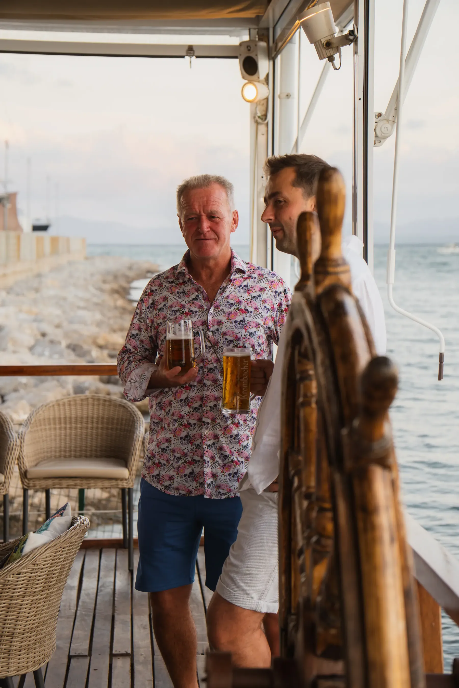 Dos amigos charlando con una cerveza en la terraza de Aqua
