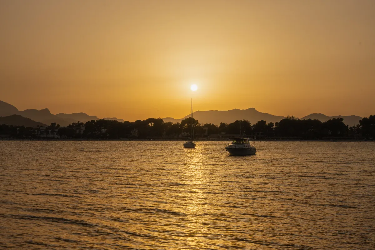 Atardecer dorado sobre las barcas de la bahía de Alcudia