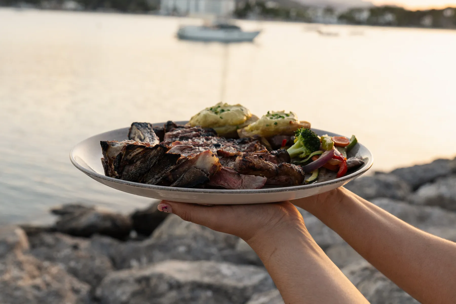 Plato de carne a la brasa servido junto al mar