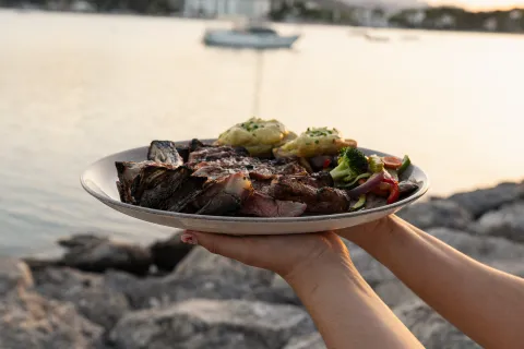 Plato de carne a la brasa servido junto al mar