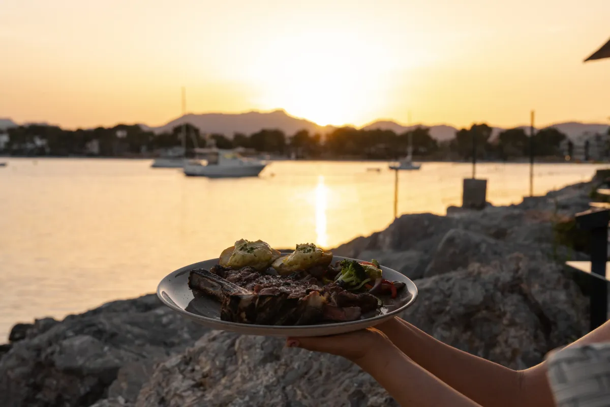 Plato de carne a la brasa servido a contraluz del atardecer