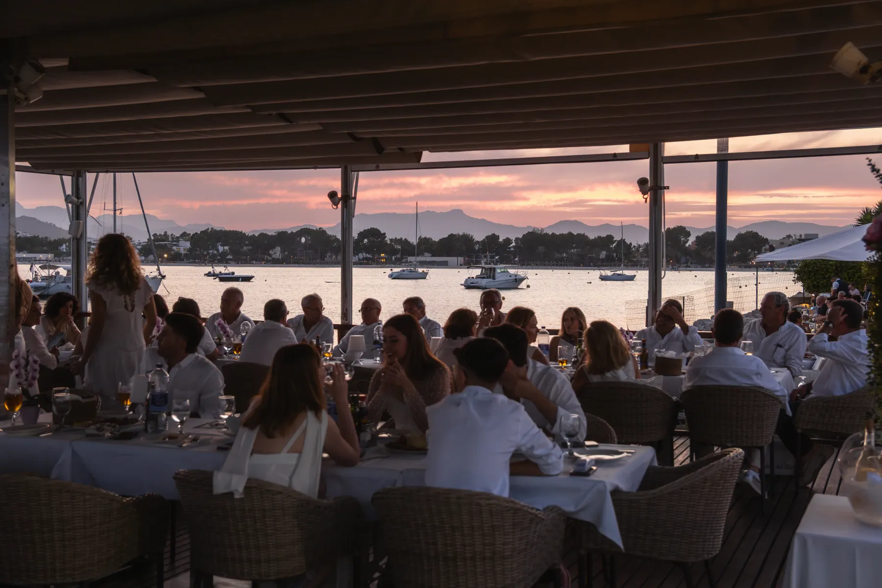 Invitados cenando al atardecer en un evento privado en Aqua