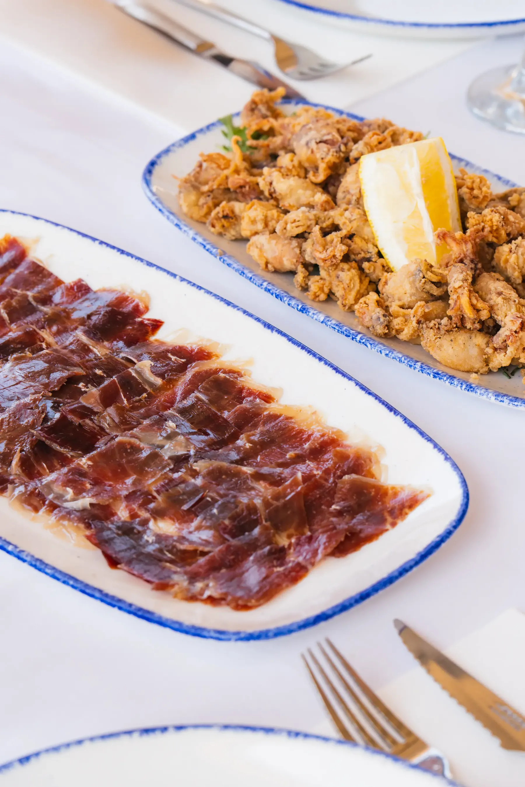 Jamón ibérico y calamares fritos servidos en Aqua