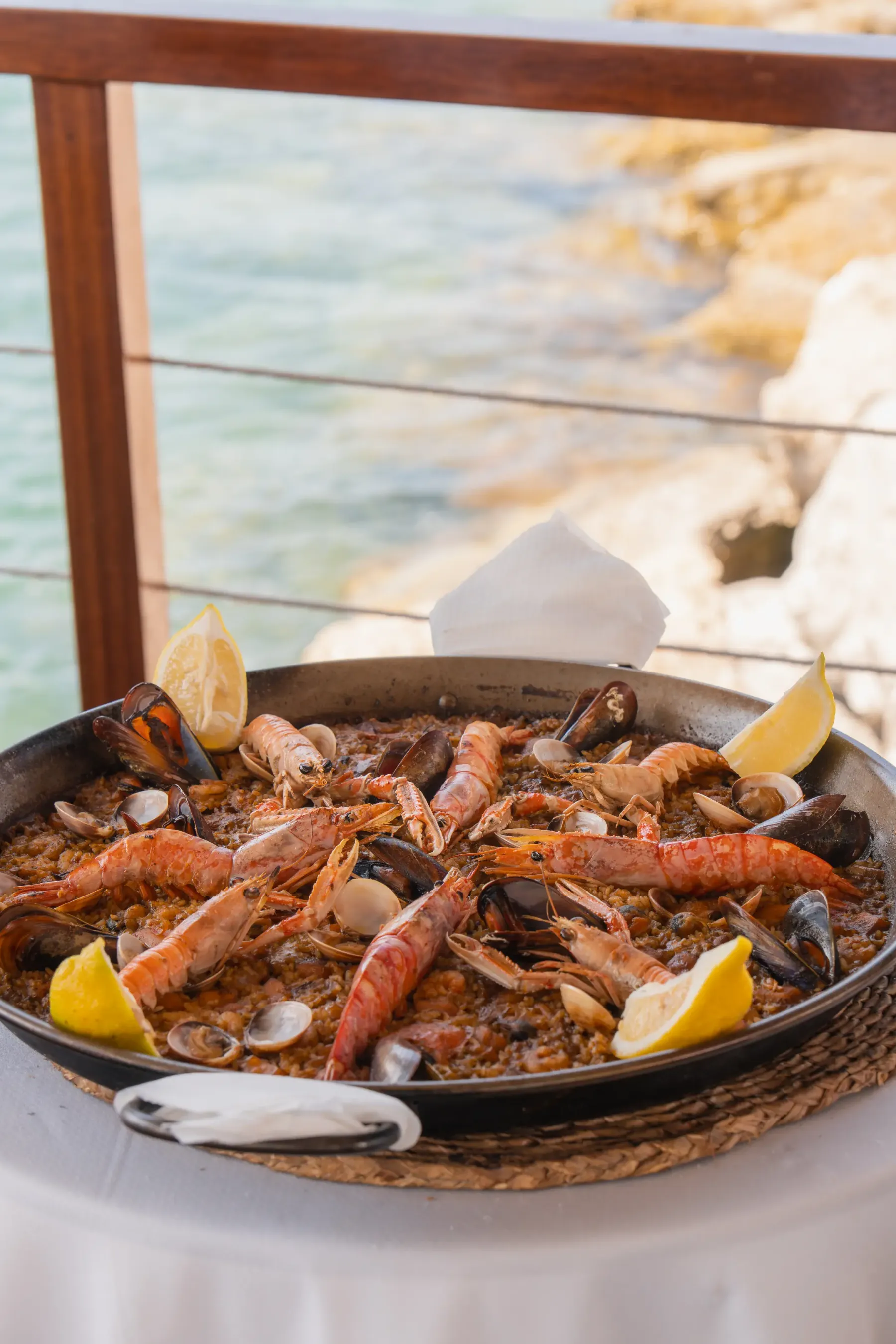 Paella de marisco con cigalas servida frente al mar