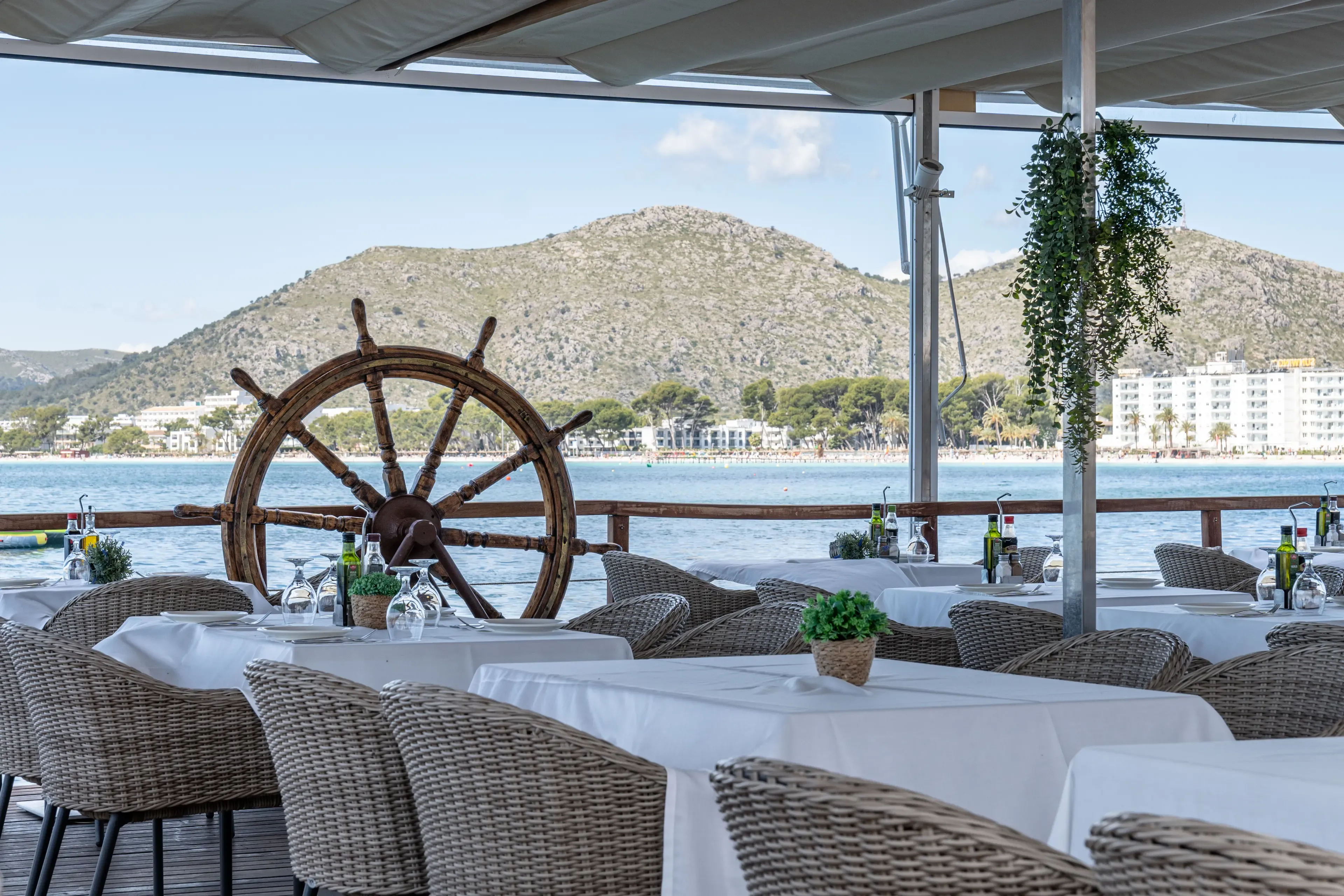 Terraza del restaurante Aqua con mesas vestidas y vistas a la bahía de Alcudia