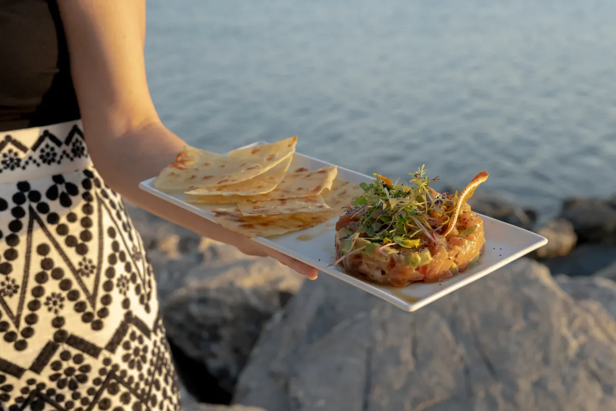 Tartar servido con crujiente de pan junto al mar