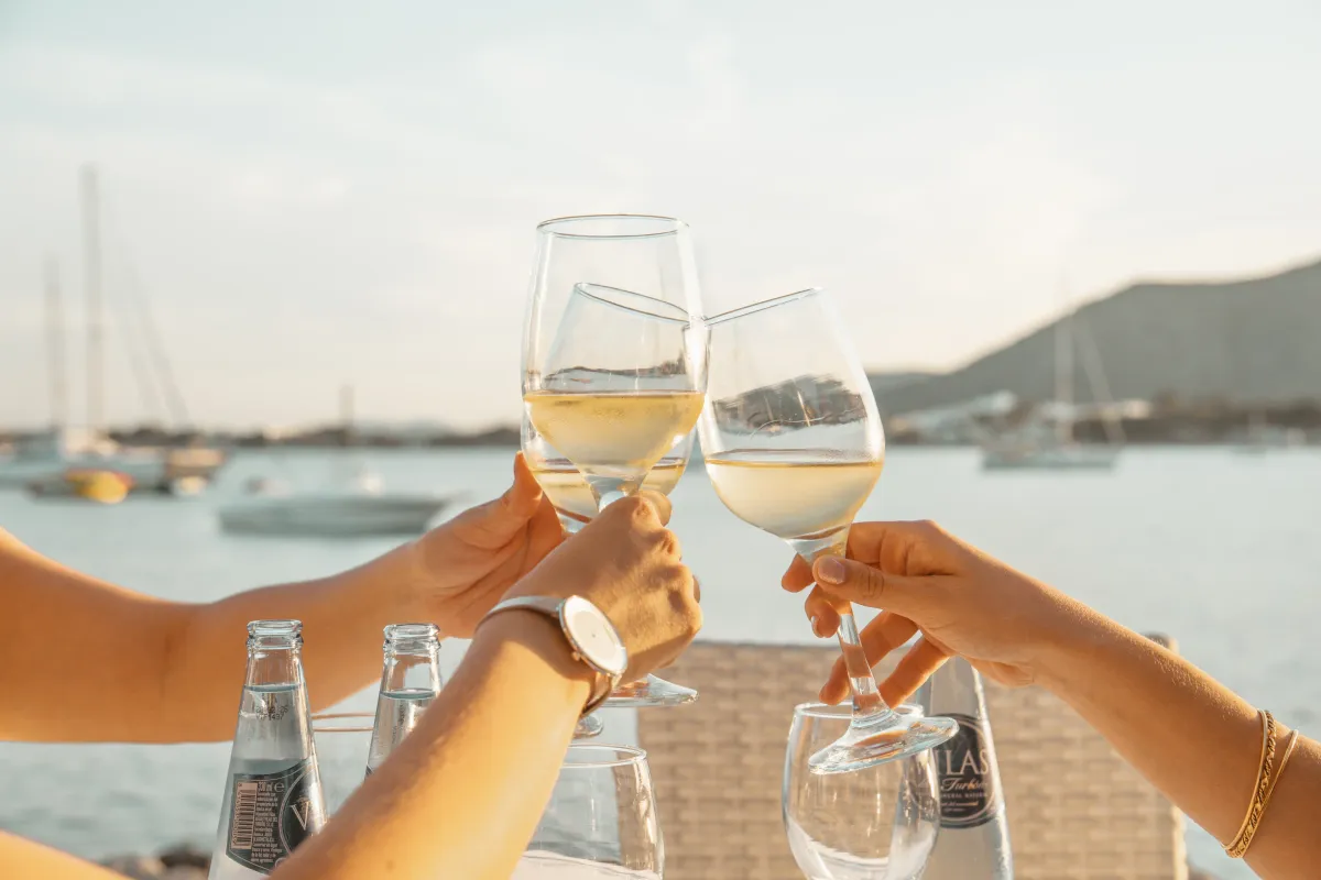 Brindis con vino blanco en la terraza frente al mar